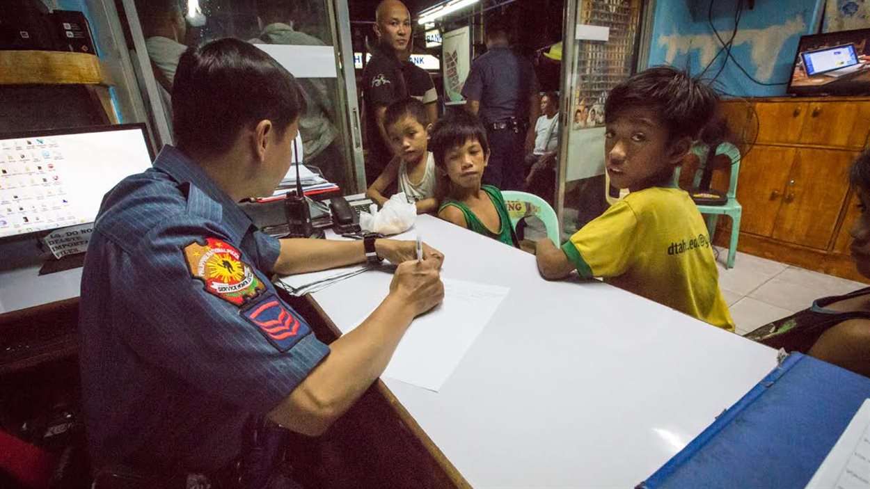 Des enfants sont assis à la centrale de police de Manille, aux Philippines, en juin 2016.