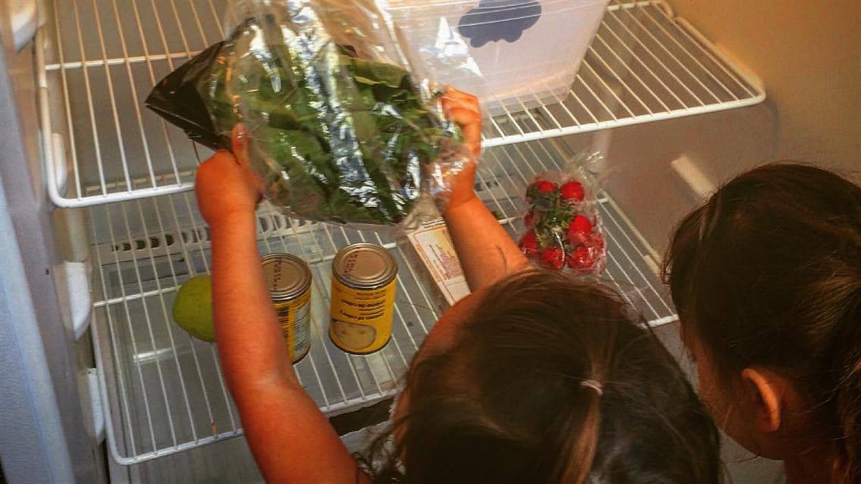 Deux jeunes filles déposent des denrées dans le frigo communautaire de sherbrooke