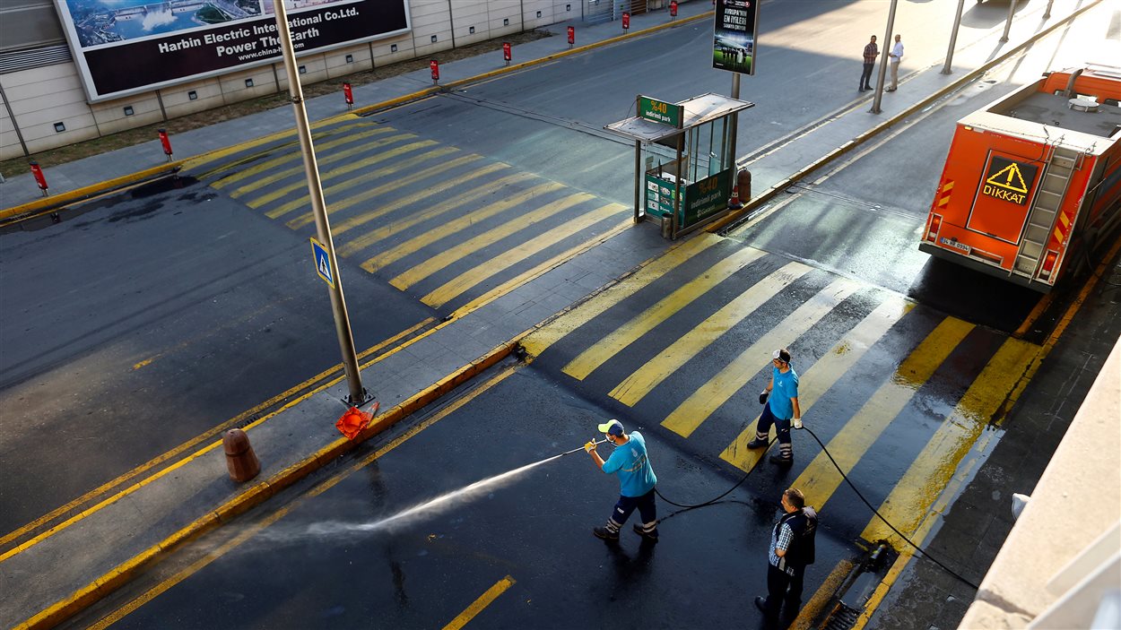 Nettoyage d'une rue de l'aéroport d'Istanbul au lendemain des explosions