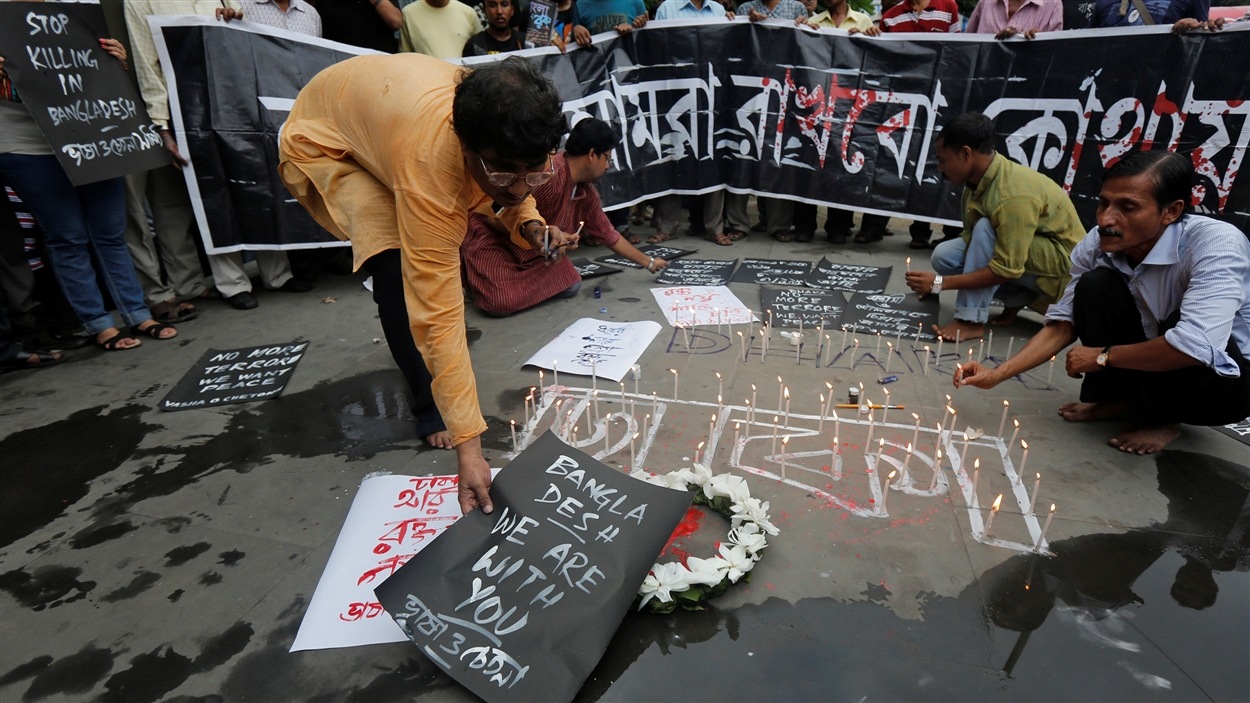 Un homme place une affiche à la mémoire des victimes du Bangladesh; en Inde, comme ailleurs en Asie, l'attaque de l'EI dans un café de Dacca a suscité un mouvement de solidarité.