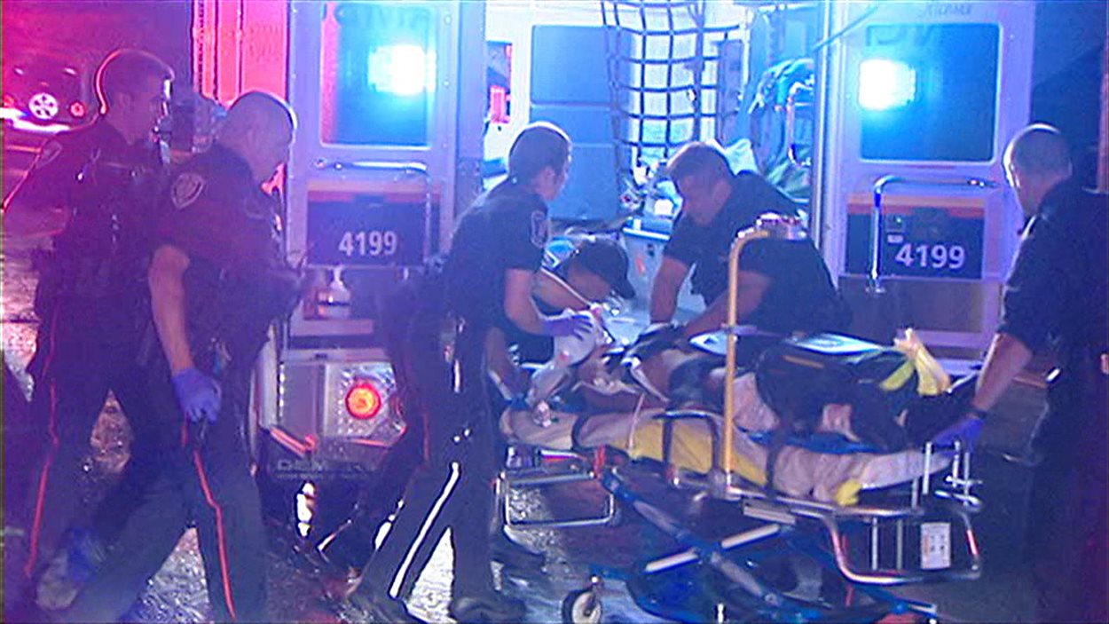 Des ambulanciers et des policiers au secours de la victime