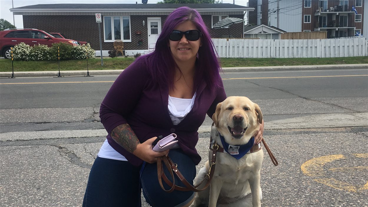 La propriétaire de la nouvelle garderie, Annie Thiebault, pose avec la chienne qui accompagne sa fille autiste.