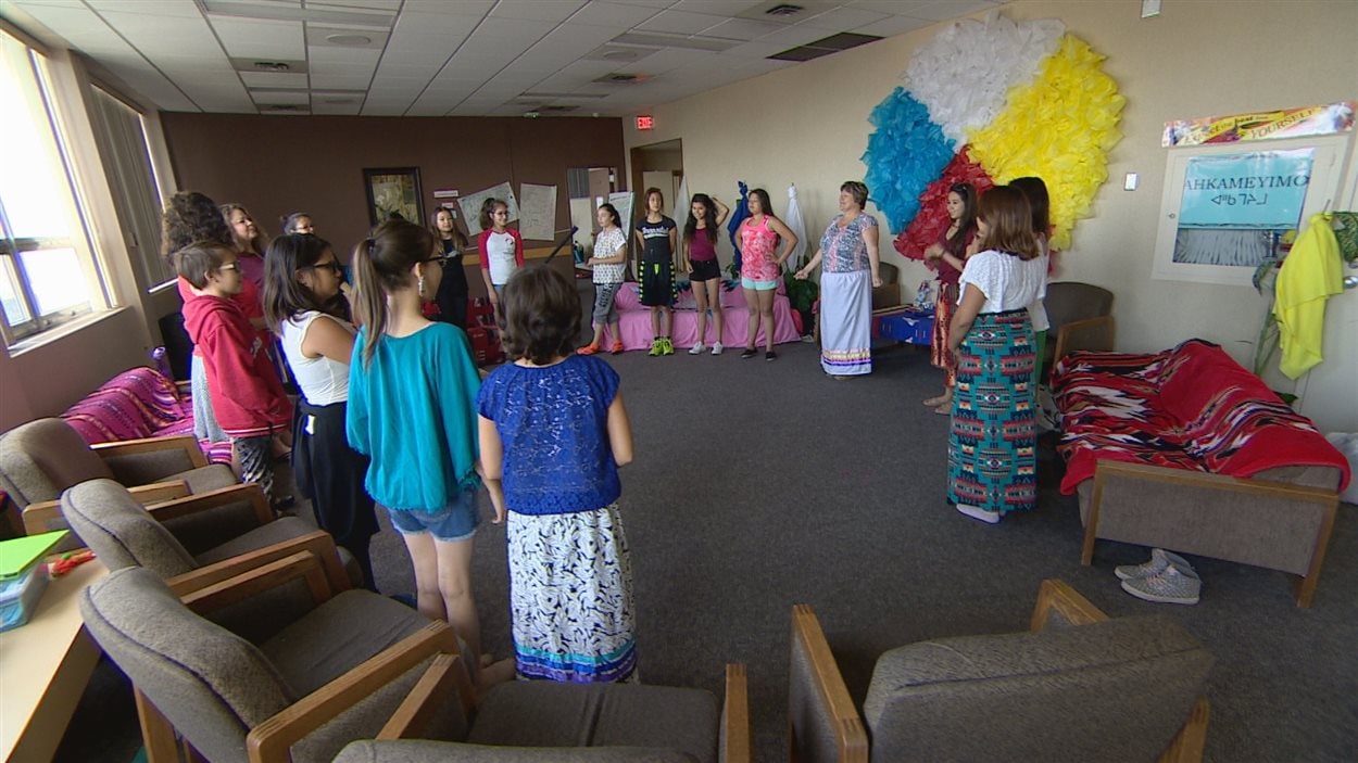 Des jeunes filles en cercle dans une salle.
