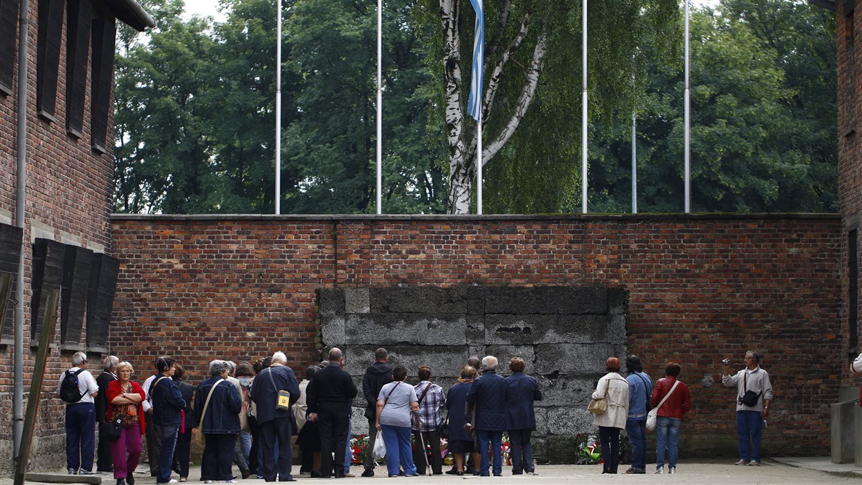 Des visiteurs rassemblés au musée de l'ancien camp nazi d'Auschwitz-Birkenau