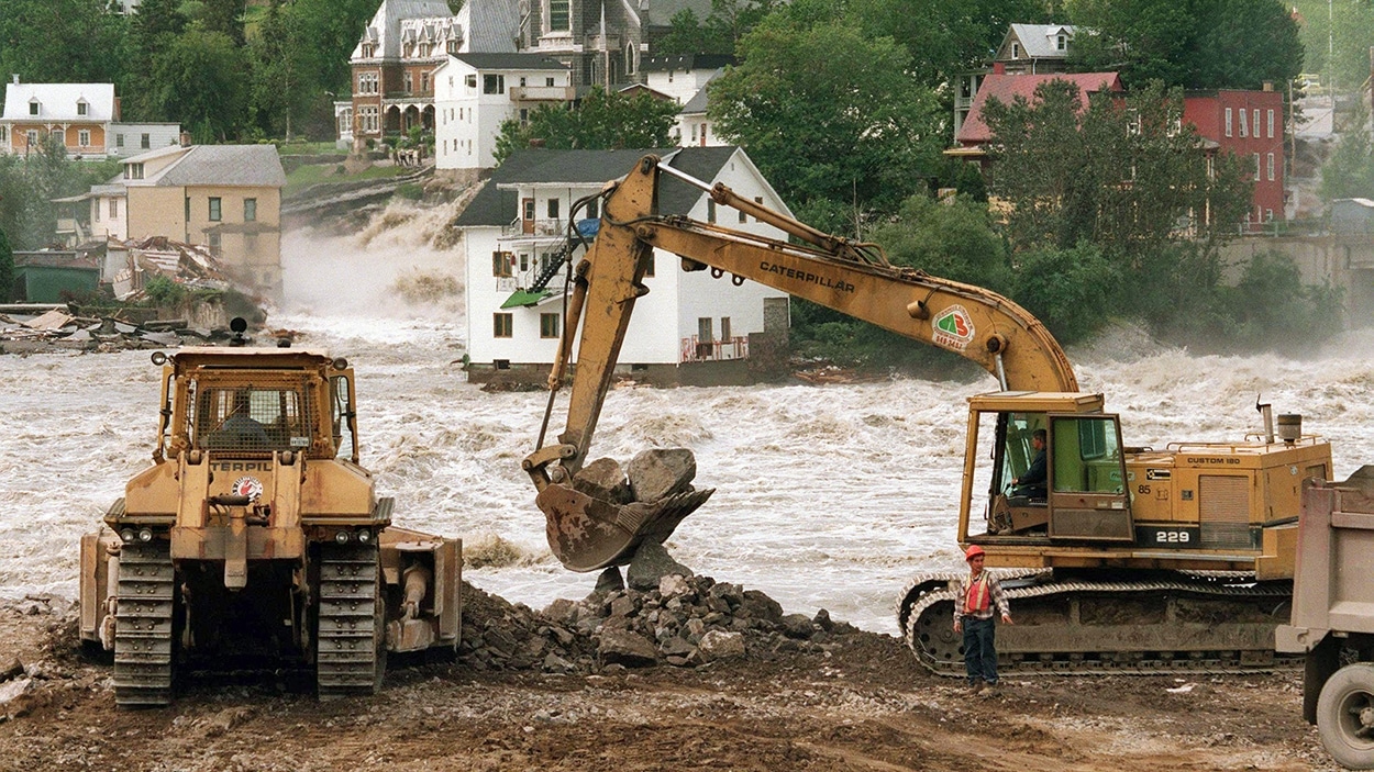 Des grues effectuent du remplissage lors du déluge du Saguenay de 1996.