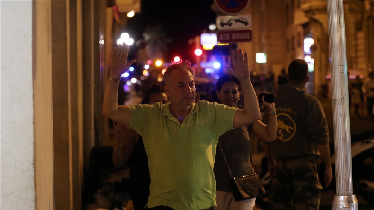 Un homme traverse un contrôle de police à Nice.
