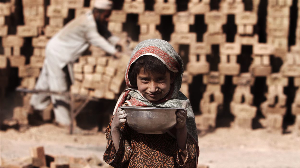 Nagina, 7 ans, pose pour une photo durant ses heures de travail dans une fabrique de briques à Jalalabad, en Afghanistan, le lundi 8 octobre 2012.