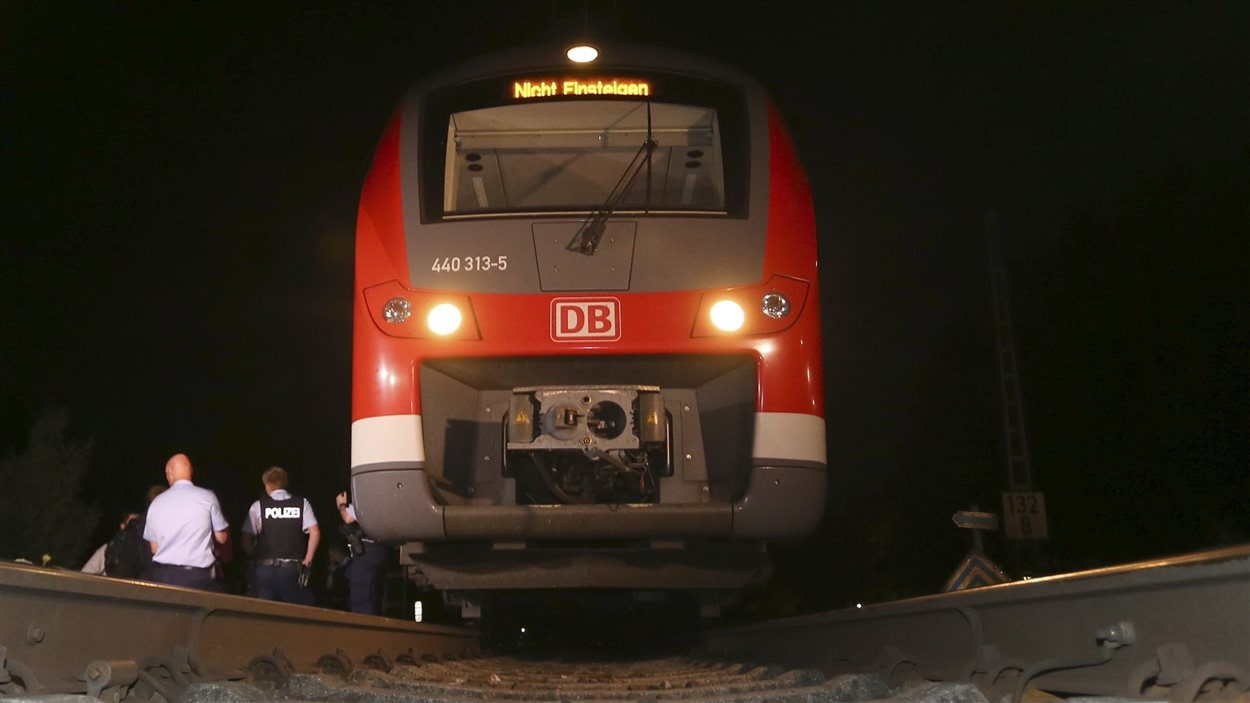 Des policiers près du train où est survenue une attaque à la hache.
