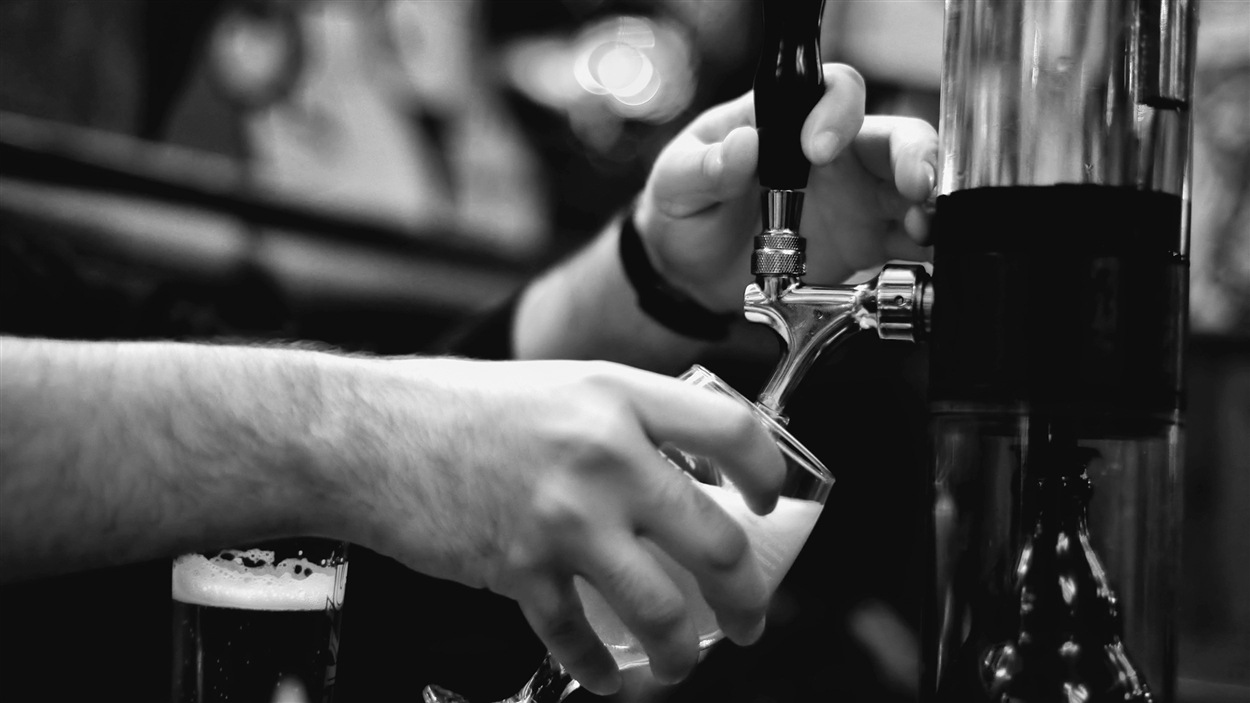 Un homme verse une bière en fût.