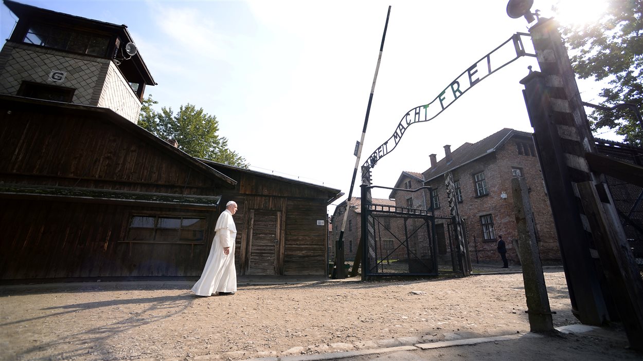 Le pape avance lentement sous la sinistre enseigne « Le travail rend libre » installée par les nazis il y a plus de 70 ans.