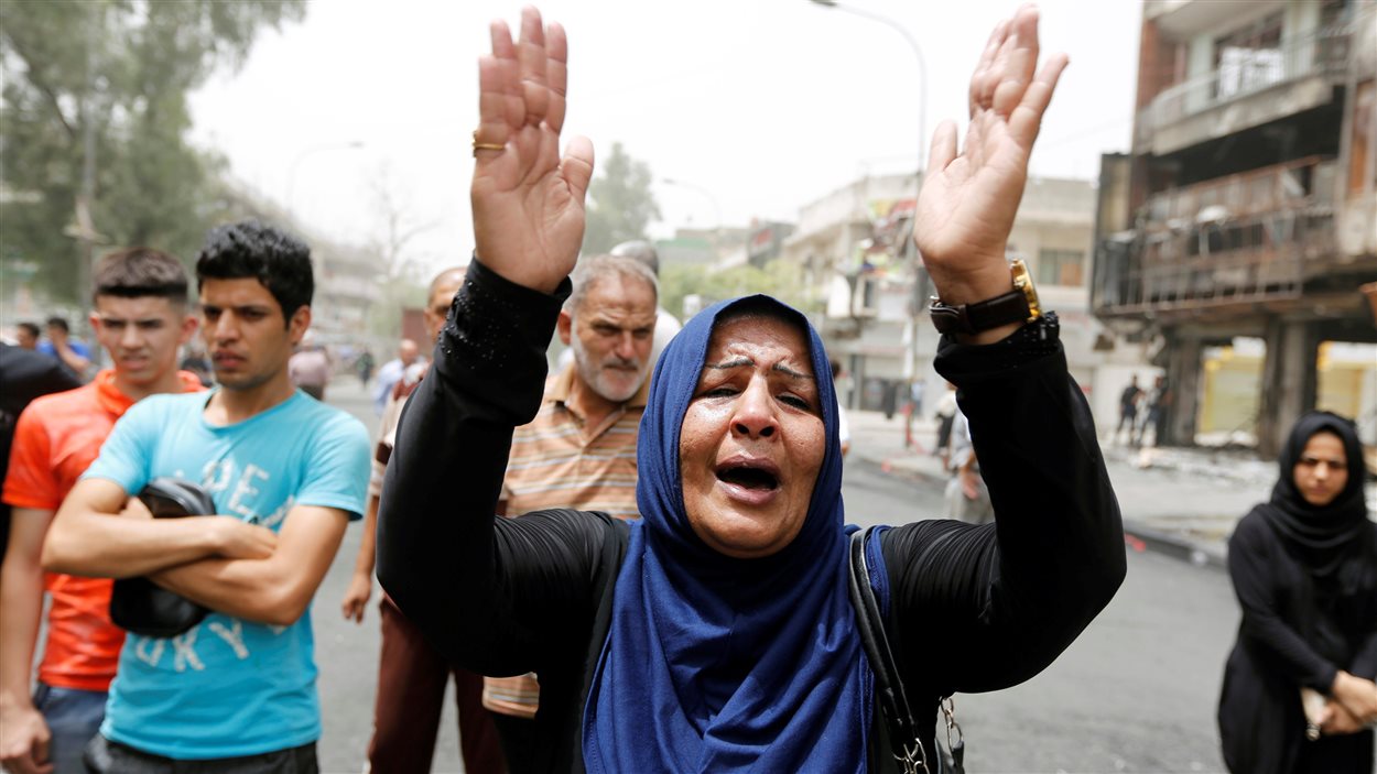 Une femme réagit le 4 juillet 2016 sur les lieux d'un attentat à la voiture piégée perpétré la veille dans une rue commerçante du quartier Karrada de Baghdad, en Irak.