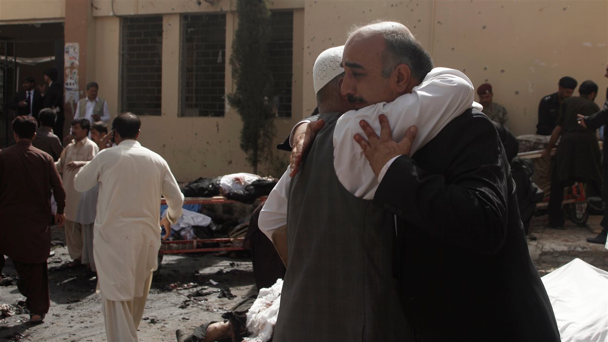 Des proches des victimes se réconfortent sur les lieux où la bombe a explosé.