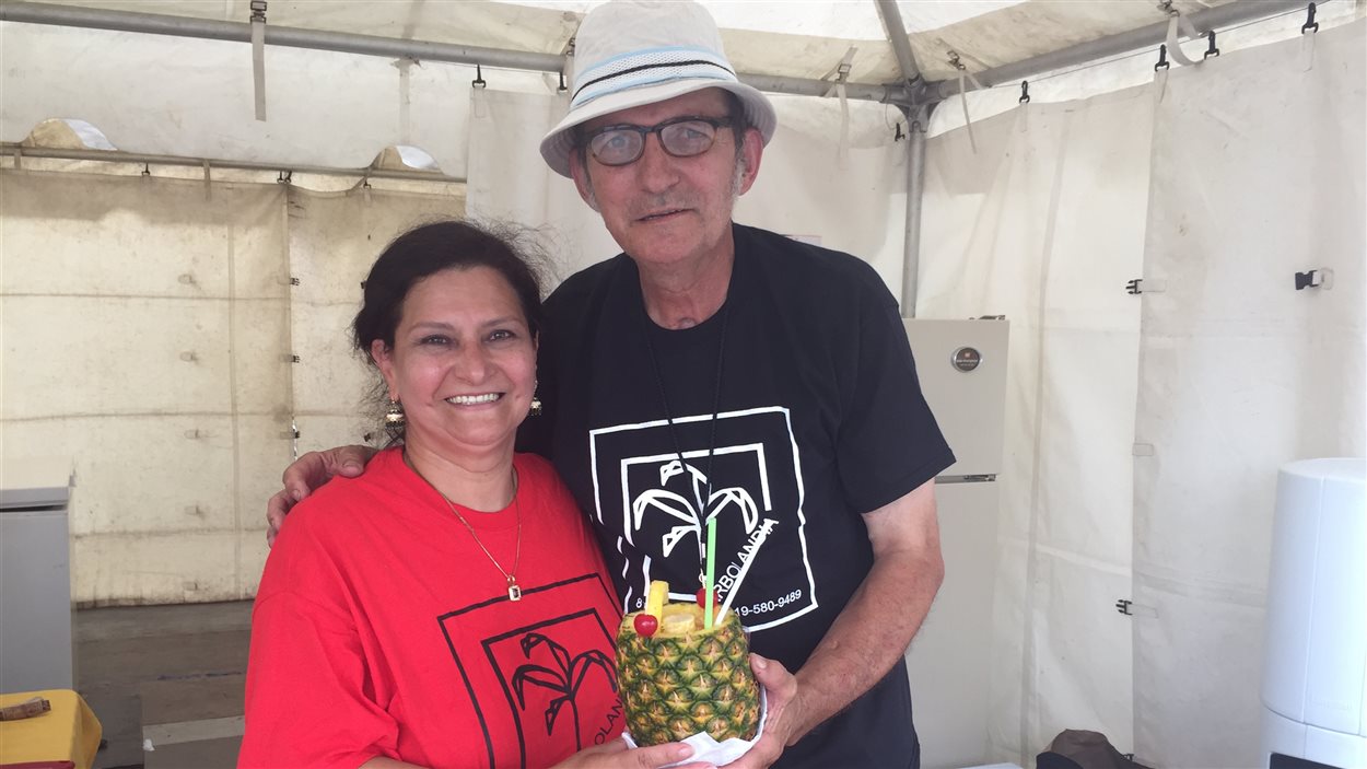 Alba Lucia et Francisco Javier Rodriguez, Colombiens d'origine, servent des piña coladas dans des ananas entiers au Festival des traditions du monde de Sherbrooke.