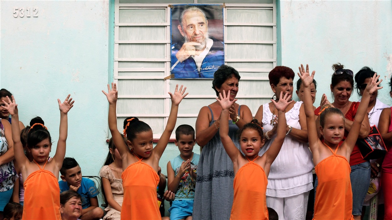 Des enfants dansent sous une photographie de l'ancien président cubain Fidel Castro.