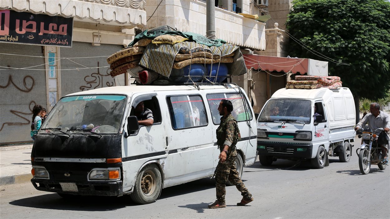 Un combattant des FDS intercepte le véhicule d'un résident de Manbij qui revient chez lui.