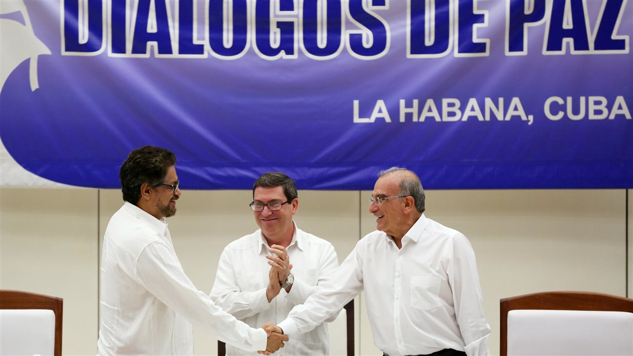 Le négociateur du mouvement FARC Ivan Marquez (à gauche) et le négociateur du gouvernement colombien Humberto de la Calle (à droite) se serrent la main, après avoir signé l'accord de paix.