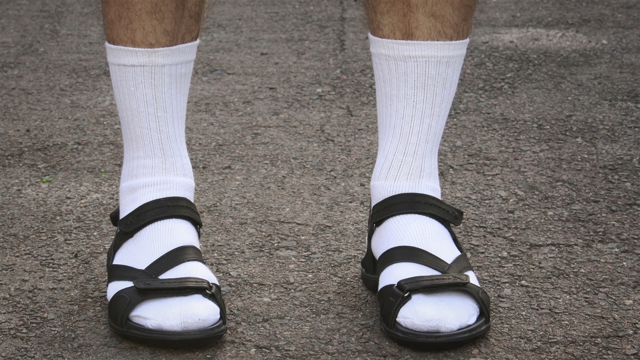 Un homme porte des bas dans des sandales