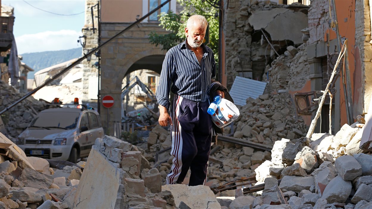 Un homme marche dans les décombres à la suite du tremblement de terre d'Amatrice.