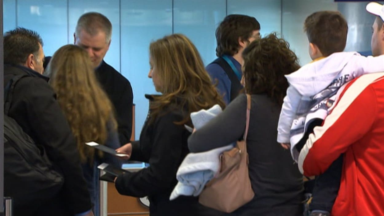 Plusieurs voyageurs font la file pour s'enregistrer à l'aéroport de Montréal.