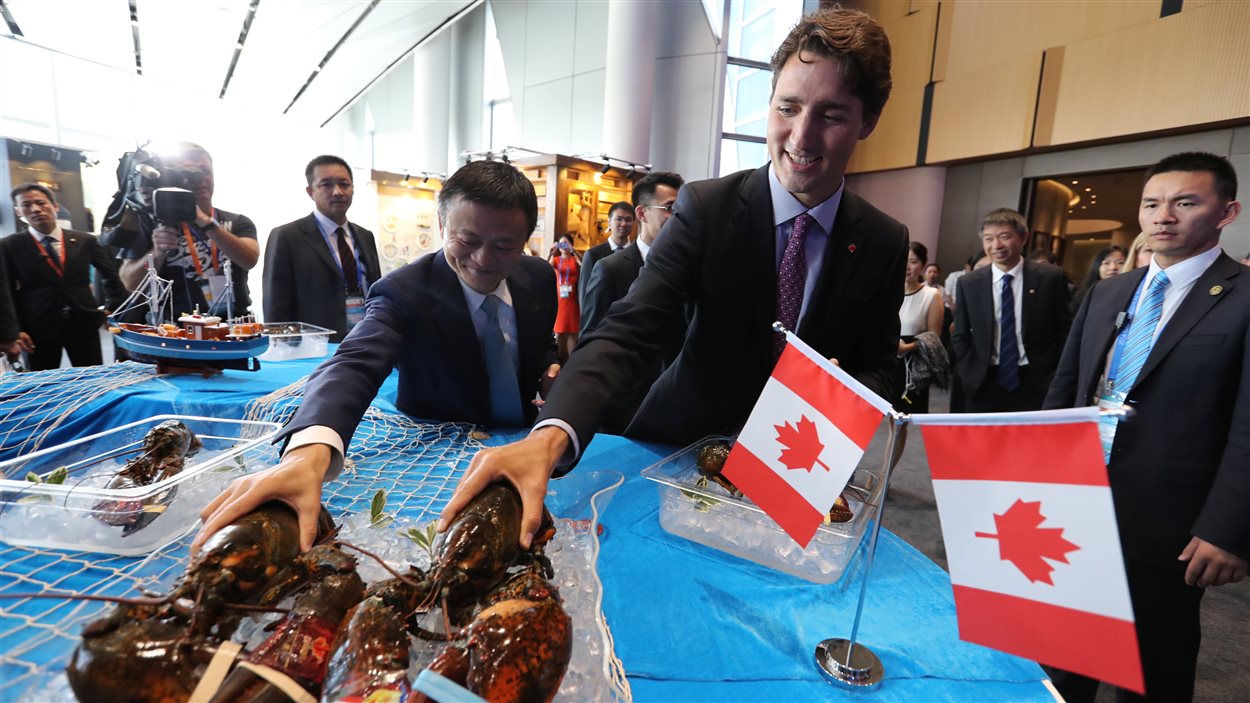 Le premier ministre du Canada, Justin Trudeau et le président exécutif du groupe Alibaba, Jack Ma, s'emparent d'un homard lors d'une rencontre à Hangzhou, en Chine.