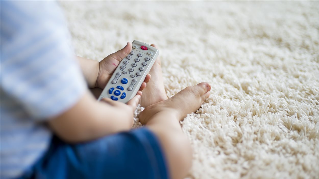 Un bébé et une manette de télévision