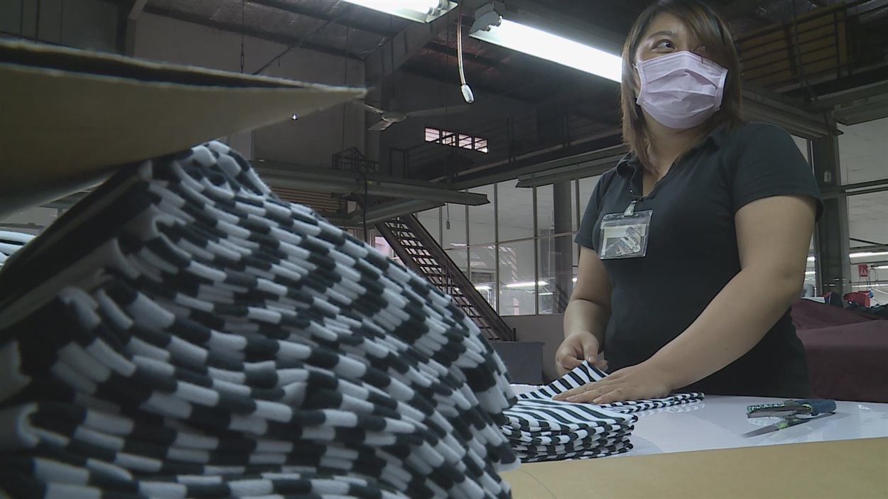 Nguyen Thi Bao coupe des tissus dans une usine au Vietnam