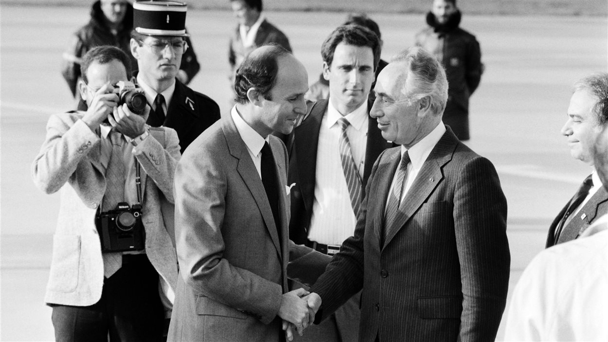 Shimon Peres et Laurent Fabius se serrent la main.