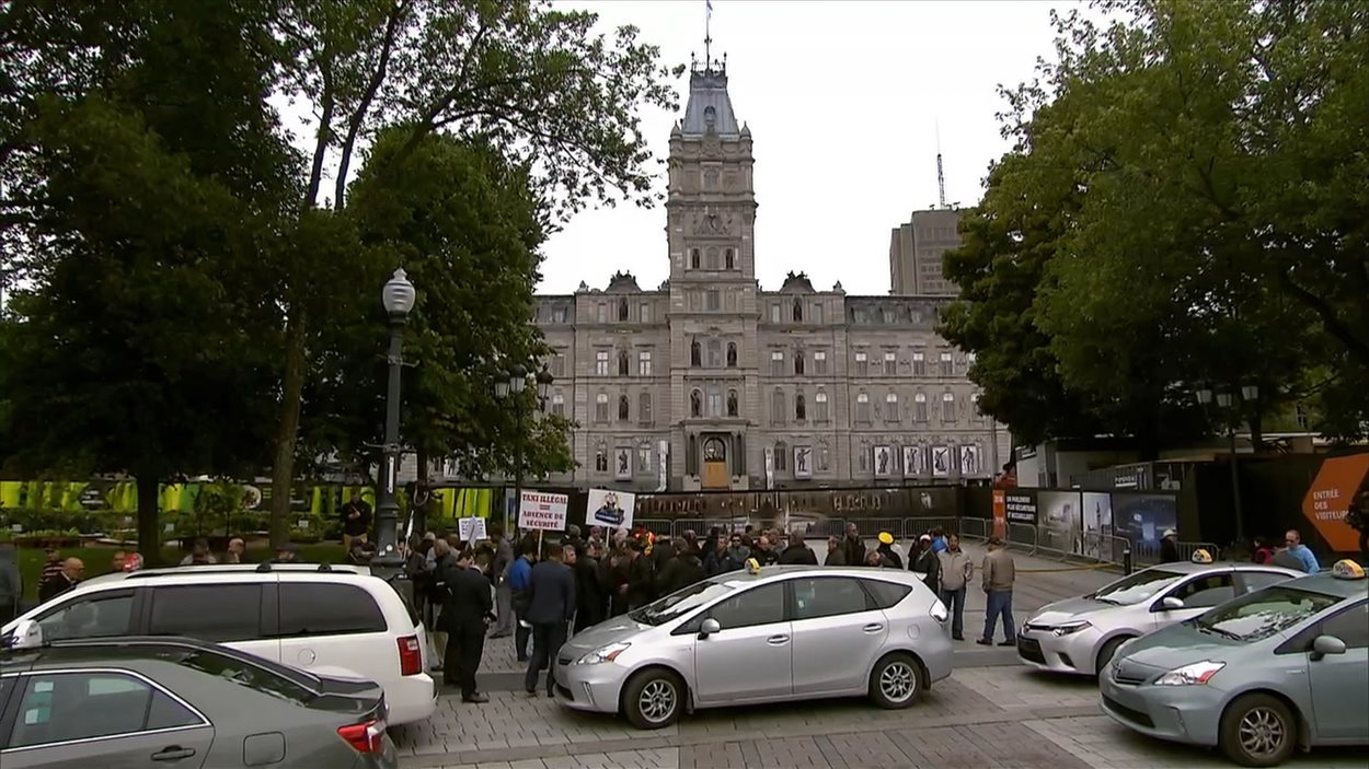 Des chauffeurs de taxi manifestent devant l'Assemblée nationale pour dénoncer le projet pilote unissant le gouvernement Couillard à Uber