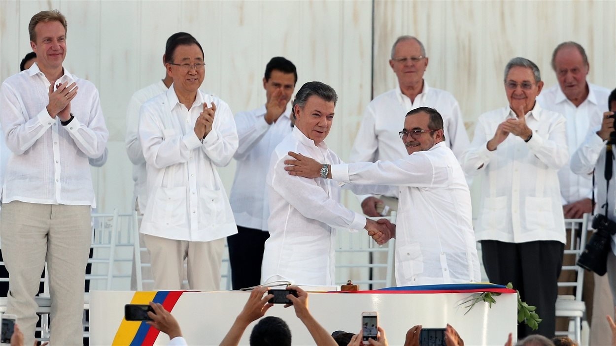 Poignée de main entre le président Juan Manuel Santos, à gauche, et le chef des FARC, Rodrigo Londono, scellant le traité de paix
