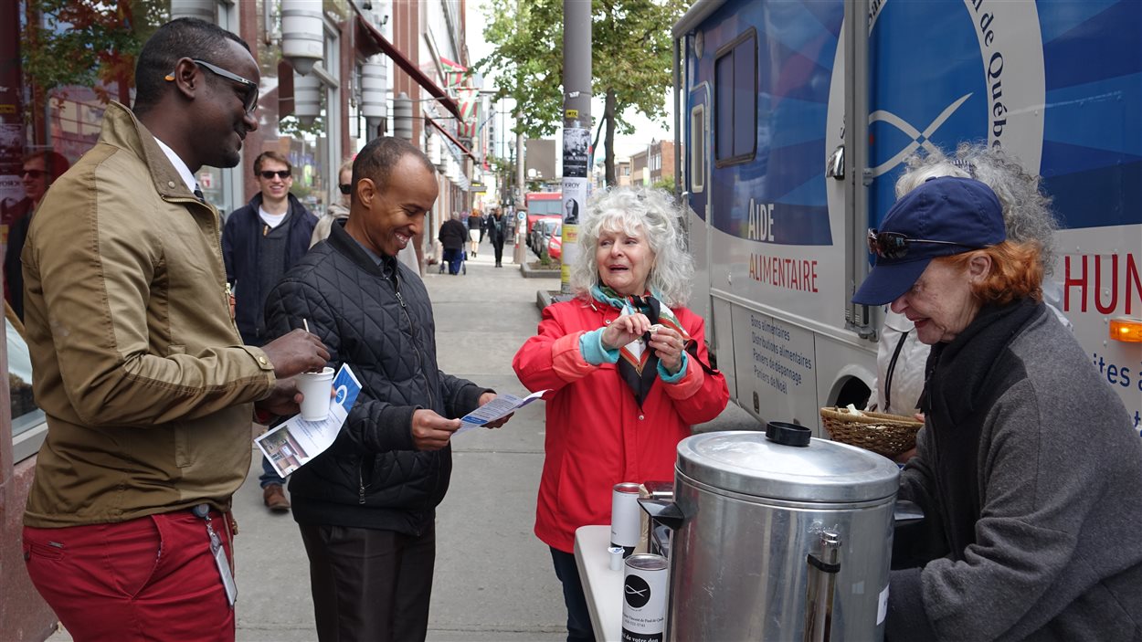 Des bénévoles de la Société Saint-Vincent-de-Paul distribuent café et biscuits aux passants