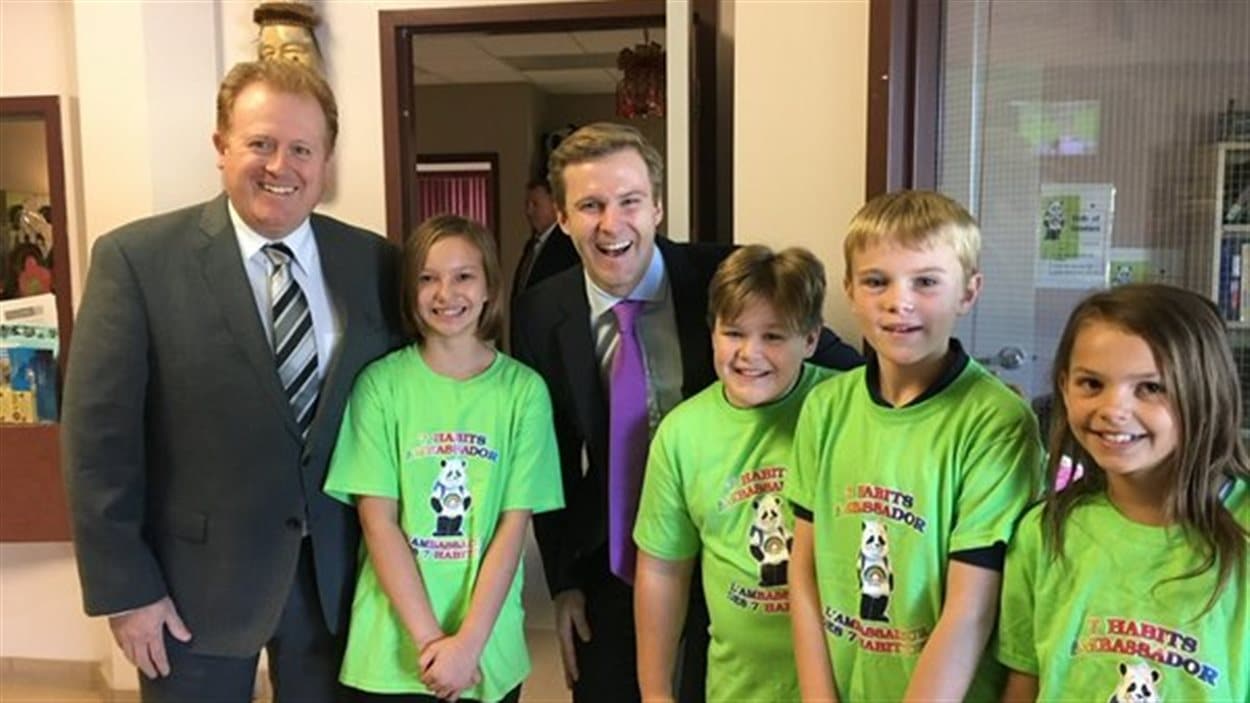 Le premier ministre Brian Gallant en compagnie du ministre de l'Éducation, Brian Kenny et d'élèves de l'école Park Street de Fredericton, où il a fait son annonce.