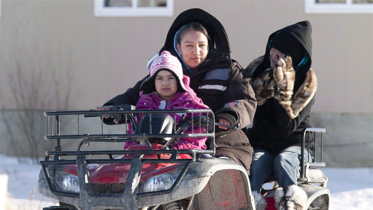 Une femme d'Attawapiskat amène des enfants à l'école.