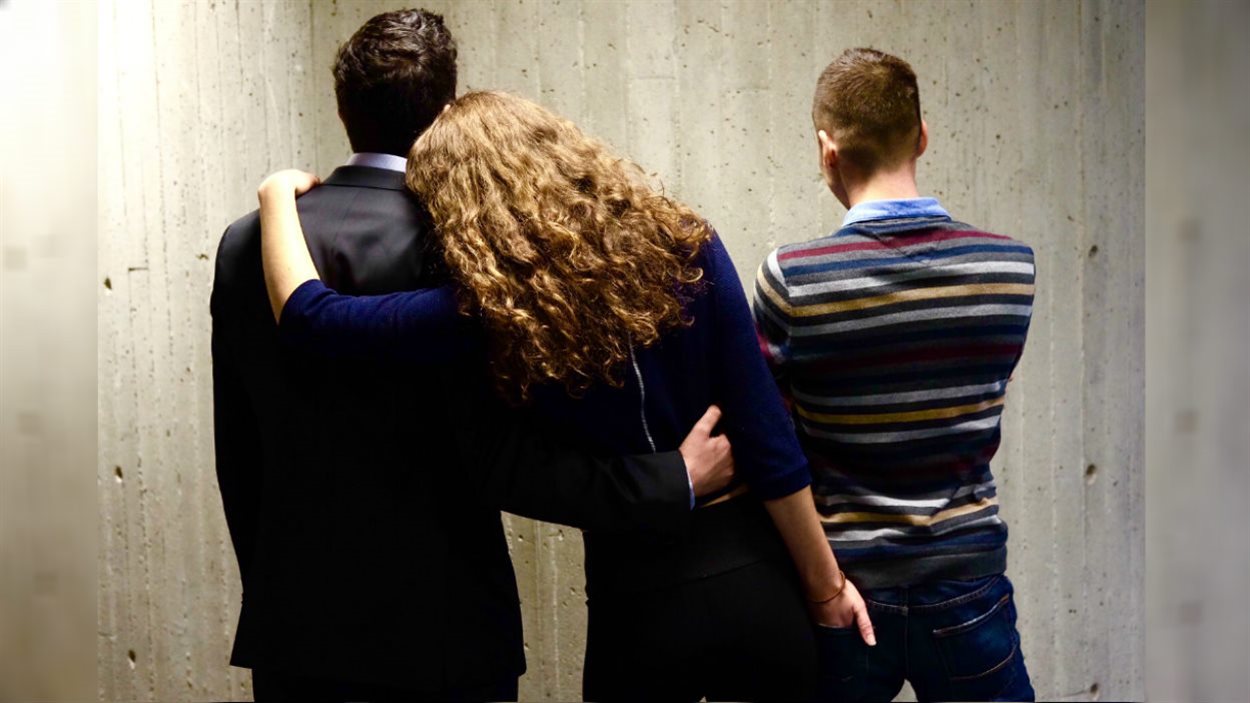 Une femme polyamoureuse enlace deux hommes