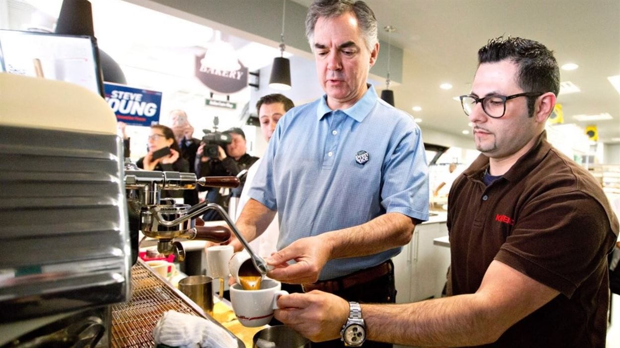 Jim Prentice apprend à faire un espresso auprès de Paolo Pucci, au Italian Centre à Edmonton, la veille de l'élection provinciale albertaine, le 4 mai 2015.
