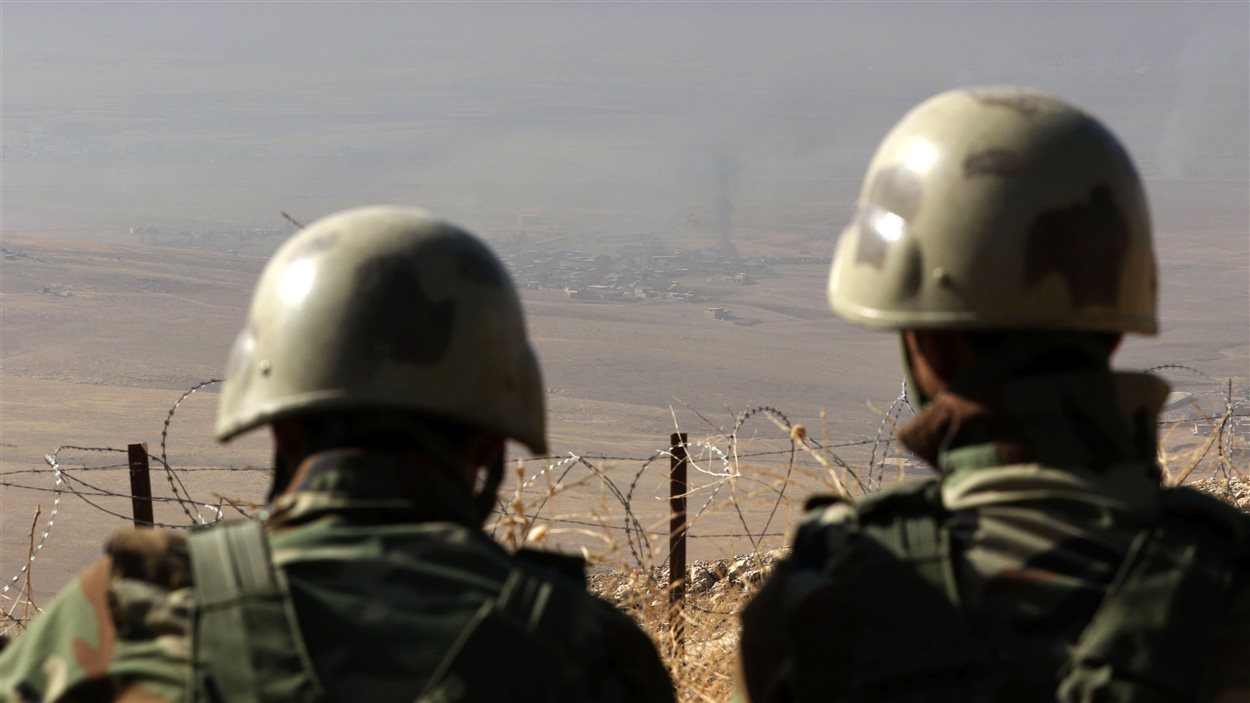 Des peshmergas positionnés au sommet du mont Zardak, à environ 25 km au sud-est de Mossoul, observent un village sous contrôle de l'EI.