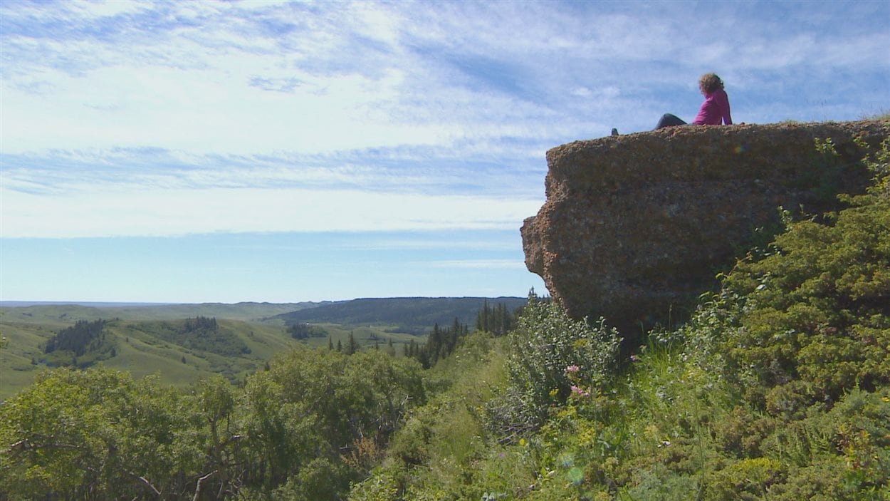 L'hydrologue Nathalie Brunet regarde le paysage vallonneux du sud-ouest de la Saskatchewan, assise sur la falaise de conglomérat des Cypress Hills.