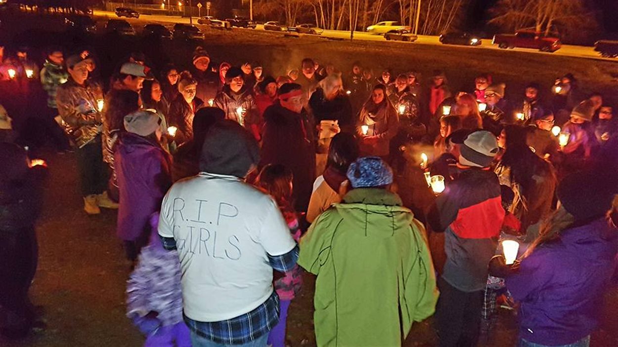 Des gens se rassemblent lors d'une veillée aux chandelles à La Ronge, pour commémorer les jeunes filles qui se sont enlevé la vie dans le dernier mois. 