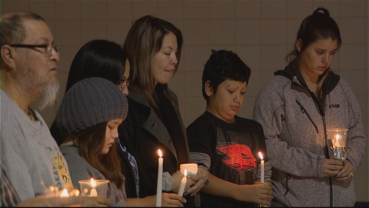 Des gens lors d'une veillée aux chandelles après le suicide de plusieurs filles dans le nord de la Saskatchewan