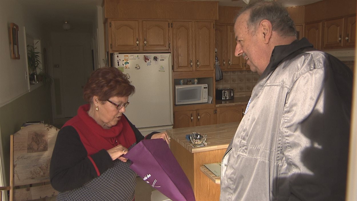 Simon Brunelle, maire de Sainte-Cécile-de-Lévrard, distribue des trousses d'information à des personnes aînées de sa municipalité.