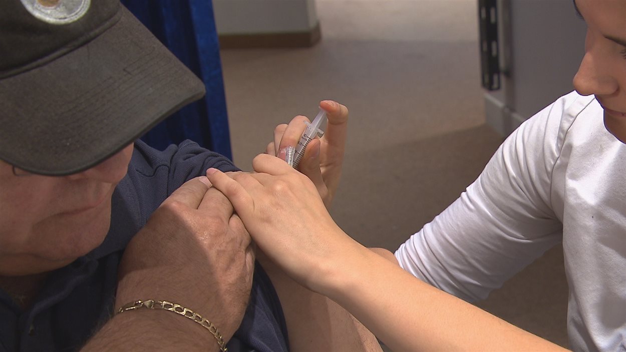 Une infirmière injecte le vaccin à un patient