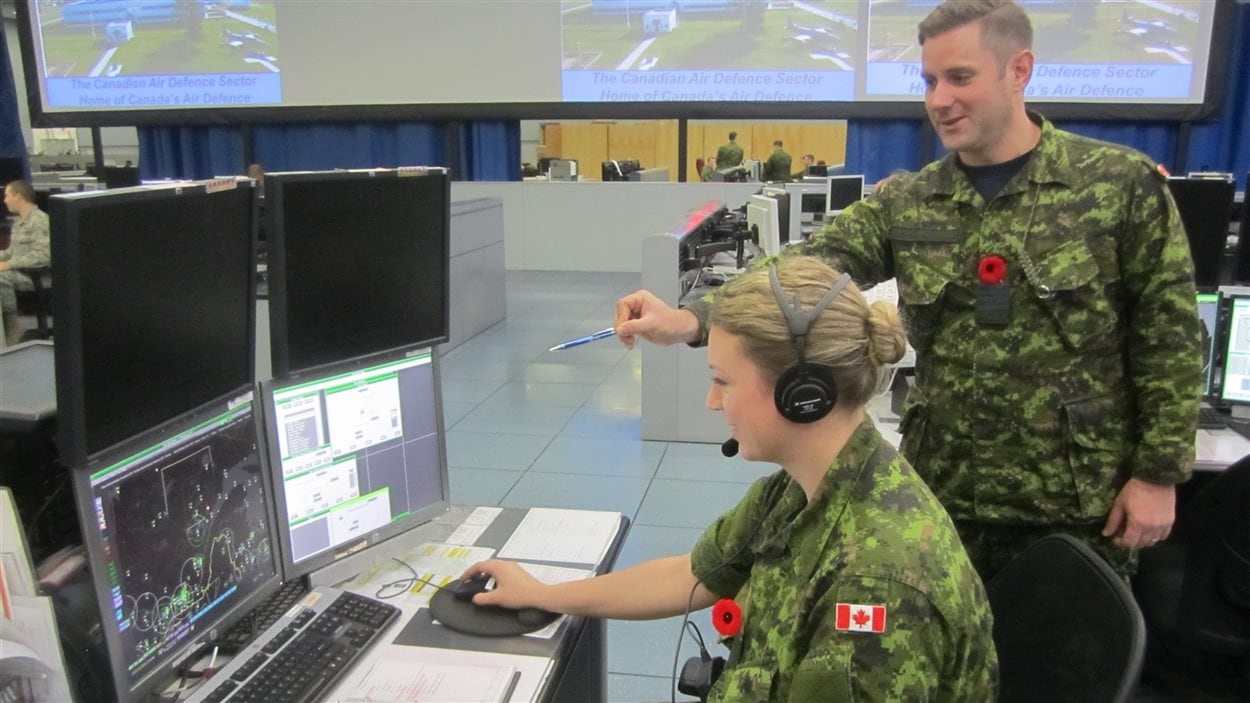 Une militaire observe son écran d'ordinateur.