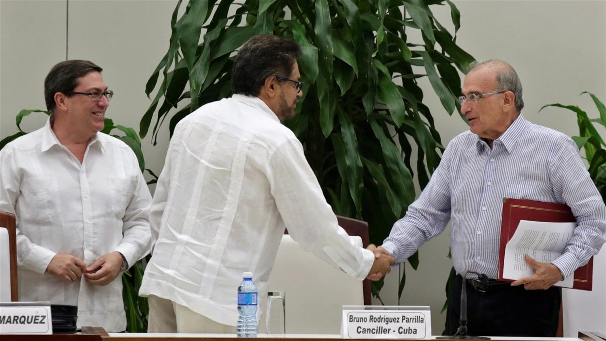 Le négociateur des FARC, Ivan Marquez, et celui du gouvernement colombien, Humberto de la Calle, se serrent la main.