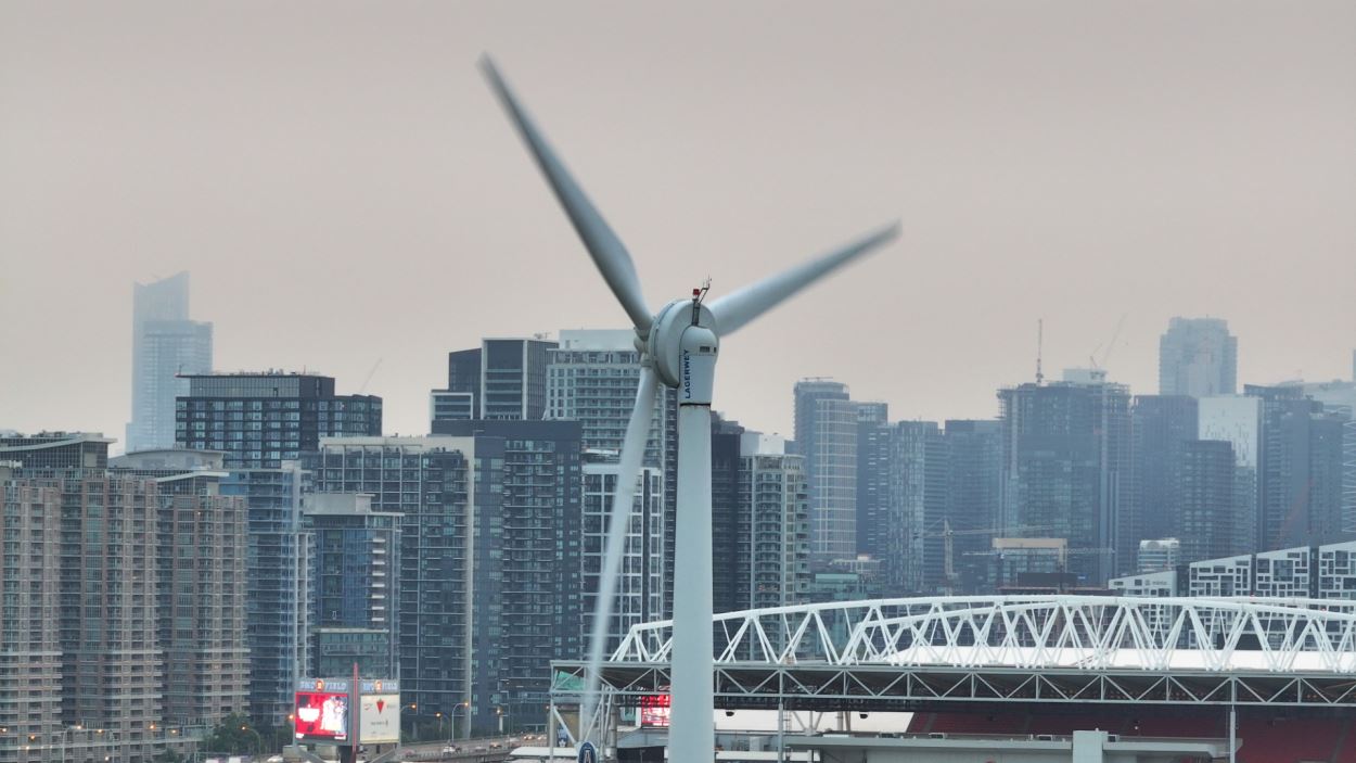 Photo prise de l’éolienne du Parc des expositions de Toronto avec le Village Liberty en arrière-plan couvert de smog.