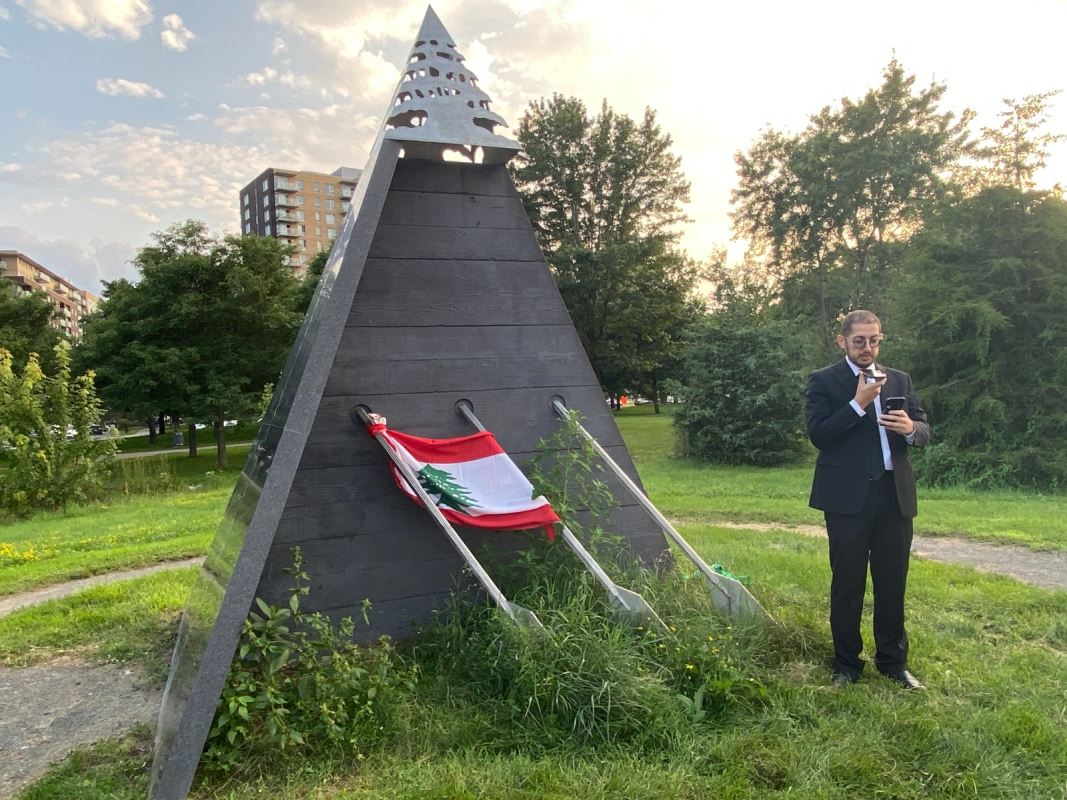Un homme devant un drapeau libanais.