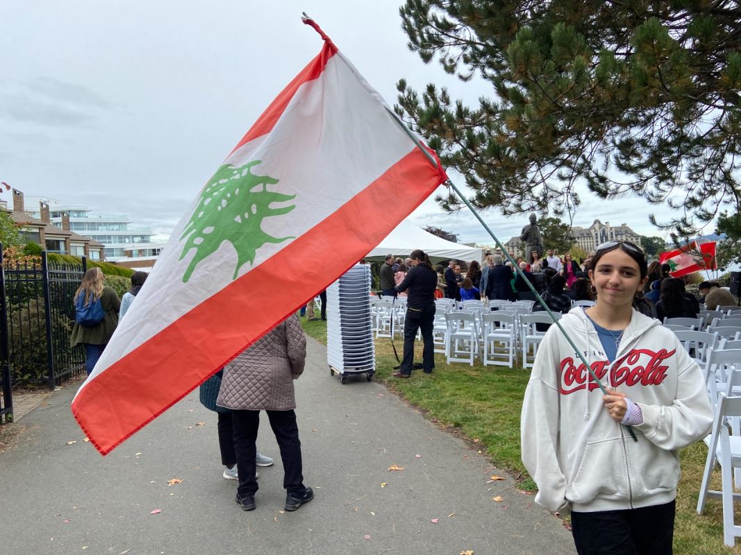 Une jeune fille tenant un drapeau. فتاة تحمل علماً.