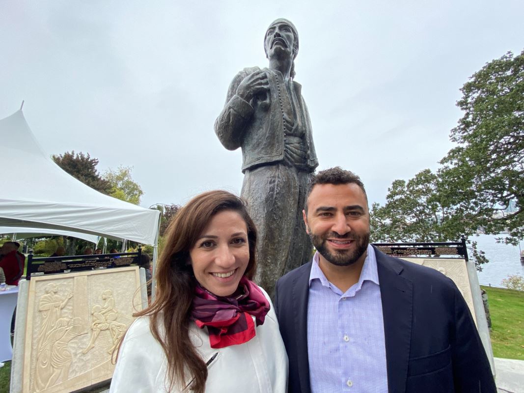 Un homme et une femme dehors devant une statue. امرأة ورجل بالخارج أمام تمثال.