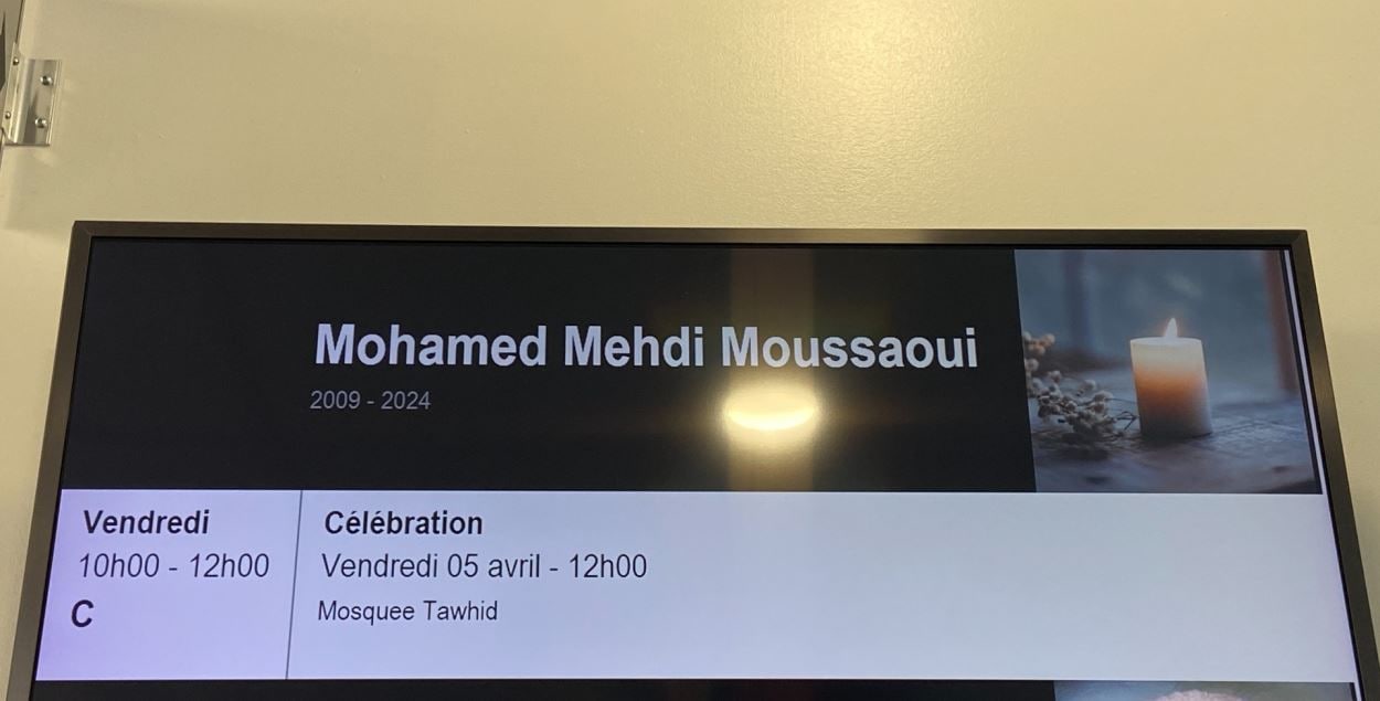 Écran d'affichage au centre funéraire Urgel Bourgie annonçant les détails des funérailles de Mehdi Moussaoui.   شاشة عرض في مركز جنازات أورجيل بورجي تعلن تفاصيل جنازة مهدي موساوي.