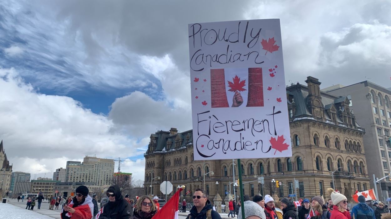 Une personne brandit une pancarte.