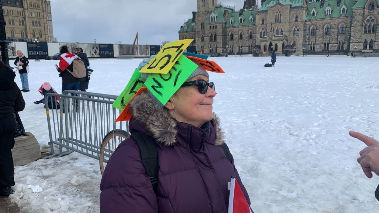 Une personne porte un chapeau où il est écrit «non» et «51».