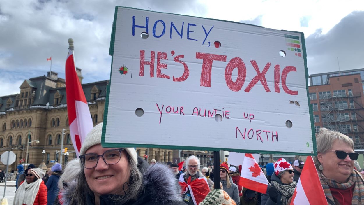 Une personne brandit une pancarte.